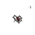 Heart-shaped jewelry piece with a red gemstone on a white background